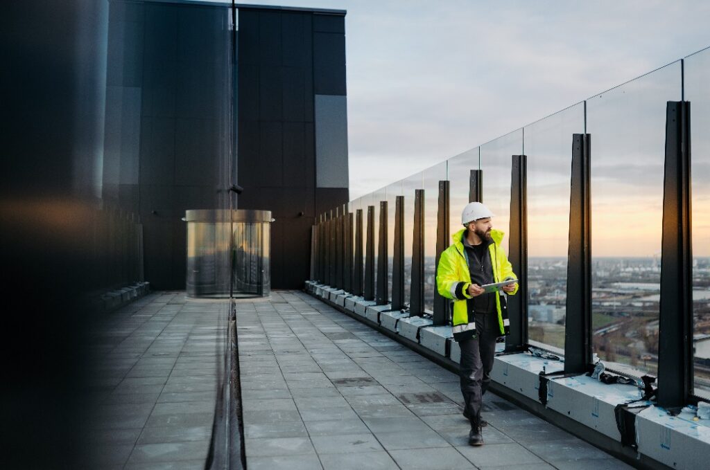 Baustellenleiter mit digitalem Tablet zur Kontrolle des Baufortschritts.